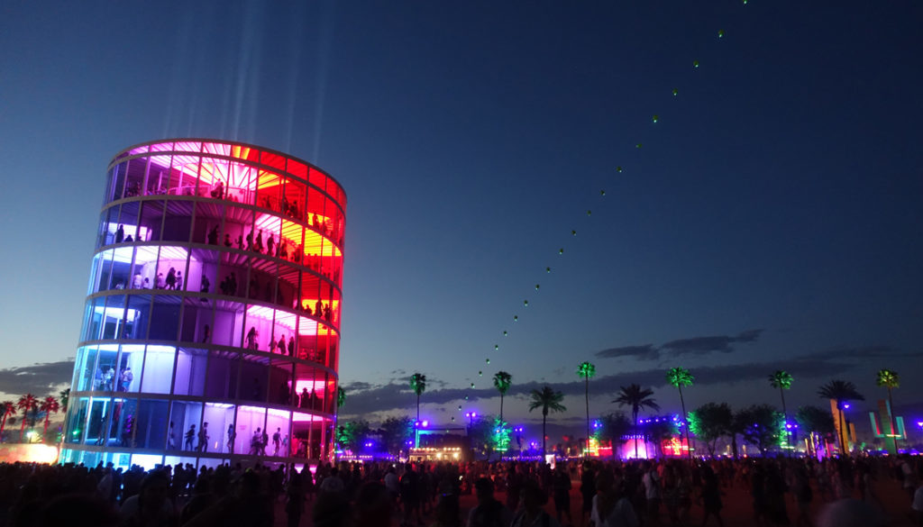 Tårn med fargerike lys og grønne palmer som lyses opp i nattmørket